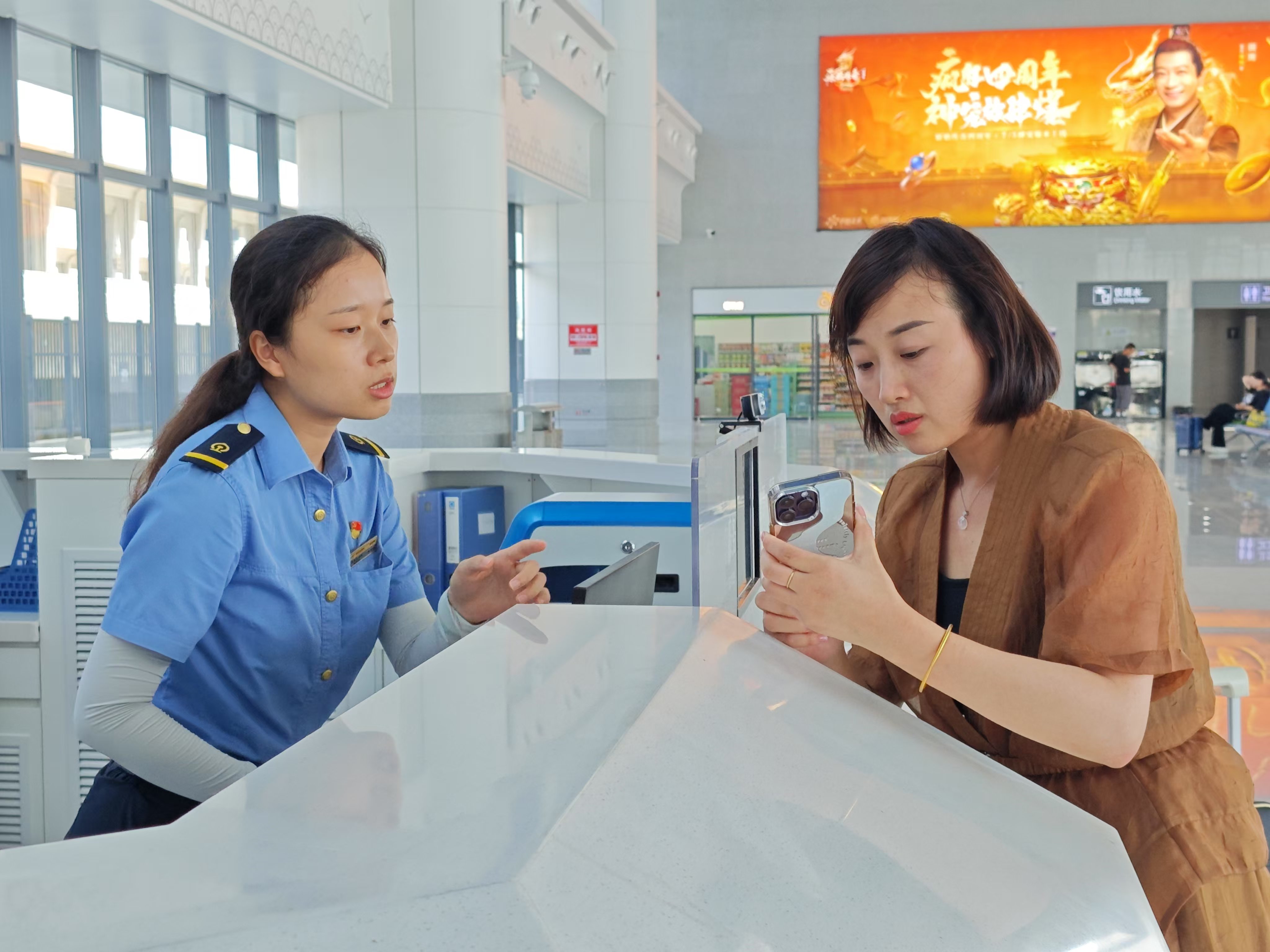 鄱陽(yáng)站服務(wù)臺(tái)的工作人員在為旅客解答疑惑。余清清 攝.jpg